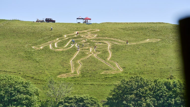 The Cerne Giant with the re-chalking team visible at top of the hill